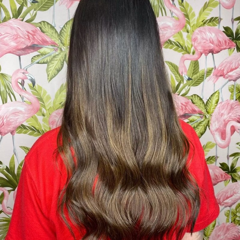 Long brunette hair with caramel balayage and soft waves