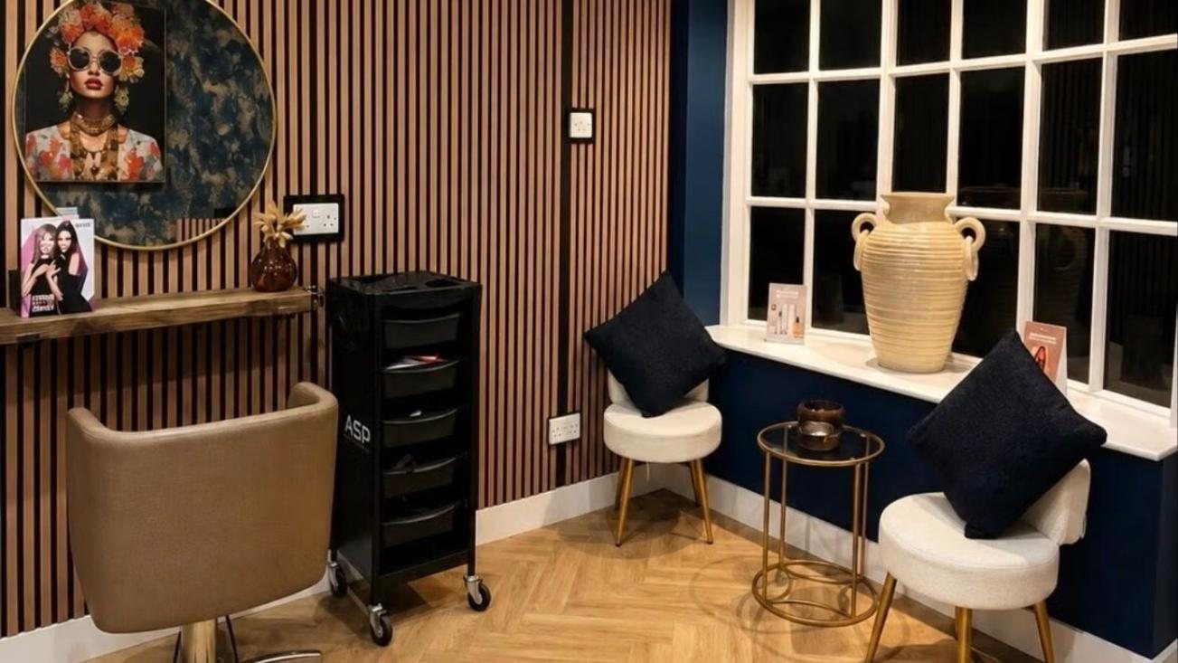 The waiting corner: cream chairs, navy cushions and a gold side table by the window