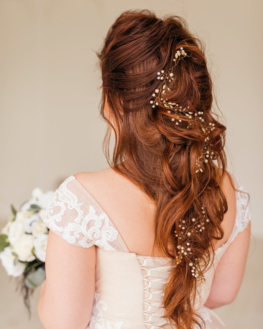 Textured boho half-up on red hair with a pearl and gold vine